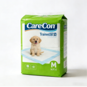 積み重ねられたグリーンパッドの横で、ペット用尿パッドに座る犬